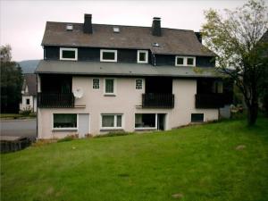 a large house on top of a grassy hill at Gasthof Haus Hubertus in Winterberg