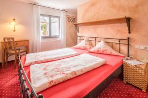 een slaapkamer met 2 bedden, een tafel en een raam bij Arndt Hotel Garni in Rust