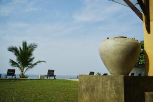 a large vase sitting on a wall next to the beach at Amanda Beach Villas in Unawatuna
