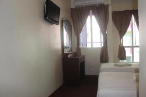 a hotel room with two beds and a television at Alonto Hotel in Sandakan