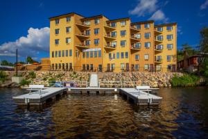 a large yellow building on the water with benches at The VUE Boutique Hotel & Boathouse in Wisconsin Dells