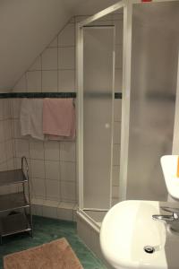 ein Badezimmer mit einem weißen Waschbecken und einer Dusche in der Unterkunft Gasthof Zur Hohen Hunau in Schmallenberg