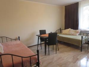 プリモルスコにあるAstara Apartmentsのベッド2台、テーブル、椅子が備わる客室です。
