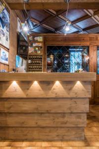 カラルツォにあるHotel Ferroviaの木製の壁と照明が備わるワインセラーのバー