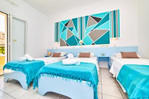 マリアにあるVillage Oasisのベッド3台 青と白の部屋