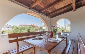 a dining room with a table and two large windows at Apartments Klaudija in Pula