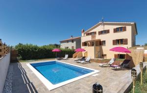 a villa with a swimming pool in front of a house at Apartments Klaudija in Pula