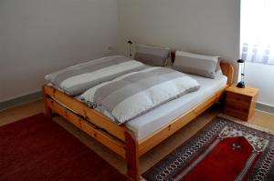 a bedroom with a wooden bed with a red rug at Villa Am Rosenfelspark in Lörrach