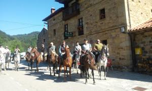 Posada Casa Molleda في Pejanda: مجموعة من الأشخاص يركبون الخيول أمام المبنى