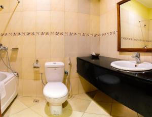 
a white toilet sitting next to a sink in a bathroom at Mvuli Hotels Arusha in Arusha
