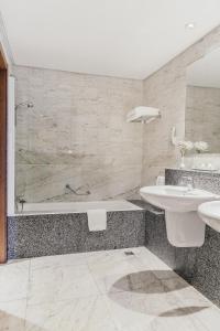a bathroom with a tub and a sink and a shower at Parador de Baiona in Baiona