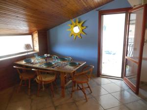 a dining room with a table with chairs and a clock at Casa Diana in Giardini Naxos