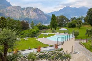 a resort with a swimming pool and mountains in the background at Villa La Rosa B&B in Bellagio