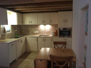 a kitchen with white cabinets and a wooden table at GKMykonos in Ano Mera