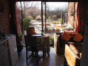a room with a table and chairs and a window at Amani Guest house Clarens in Clarens