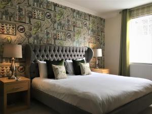 a bedroom with a large bed and a wall of plates at The Highworth Hotel in Swindon