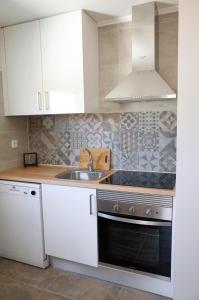 a kitchen with white cabinets and a sink at Lisbon Beach Apartments 2 in Costa da Caparica