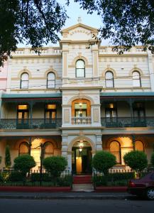 ein großes weißes Gebäude in einer Stadtstraße in der Unterkunft Avonmore On The Park Boutique Hotel in Sydney