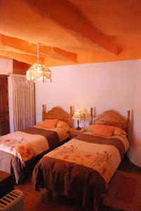 a bedroom with two beds and a chandelier at Casa Africa in Mecina Fondales