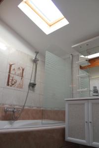 ein Badezimmer mit einer Dusche, einem Waschbecken und einem Dachfenster in der Unterkunft Maison Sous les Platanes in Saint-Pantaléon-les-Vignes