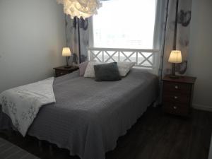 a bedroom with a bed with a window and two lamps at Apartment Skylights in Rovaniemi