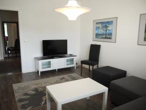 sala de estar con TV, sofá y mesa en Apartment Skylights, en Rovaniemi