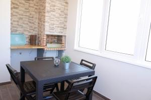 a dining room table with chairs and a window at Lisbon Beach Apartments 4 in Costa da Caparica