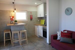 a kitchen with a red couch and a kitchen with a table at Lisbon Beach Apartments 4 in Costa da Caparica