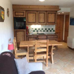 a kitchen with a wooden table and wooden cabinets at Facing the Chamonix Needles in Les Houches