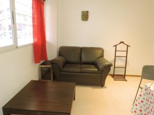 sala de estar con sofá marrón y mesa en Departamento Maipú en Rosario