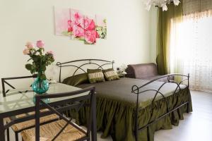 ローマにあるFloreo Guest Houseのベッドルーム1室(ベッド1台、テーブルの上に花瓶1枚付)