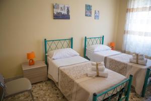 a bedroom with two beds and a chair at B&B Le Perle in Portici