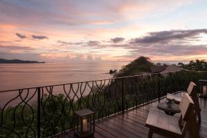 einen Balkon mit Blick auf das Meer bei Sonnenuntergang in der Unterkunft Four Seasons Resort Peninsula Papagayo, Costa Rica in Culebra