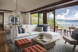 a living room with a white couch and large windows at Four Seasons Resort Peninsula Papagayo, Costa Rica in Culebra