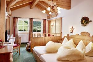 ein Schlafzimmer mit einem Bett und einem Schreibtisch in einem Zimmer in der Unterkunft Berghotel Hauserbauer in Dorfgastein