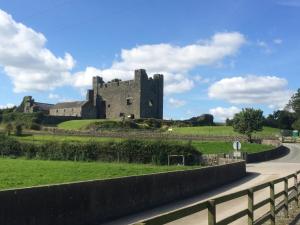 a castle on a hill with a road at Greencastle in Kilkeel