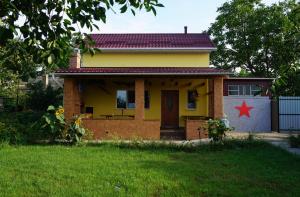 a small yellow house with a red star on it at Red Star Peoples Republic in Tiraspol +18 photos