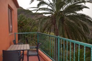 een balkon met een tafel en stoelen en een palmboom bij Casa Camilo in Vallehermoso