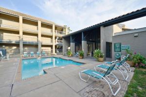 un hotel con piscina y sillas en el patio en Americas Best Value Inn & Suites Extended Stay - Tulsa, en Tulsa