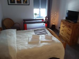 a bedroom with a bed with two towels on it at L'Orchidée in Lassay