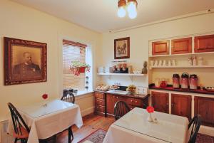 a dining room with two tables and a kitchen at Jailhouse Inn in Newport