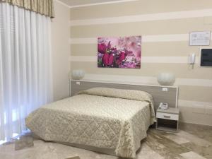 a bedroom with a bed and a painting on the wall at Affittacamere Duomo in Gela