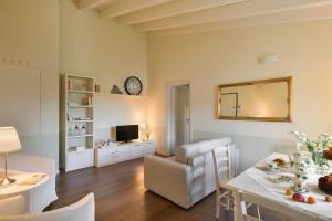 salon ze stołem jadalnym i salon z lustrem w obiekcie Appartamenti Palazzo Scolari w mieście Polpenazze del Garda
