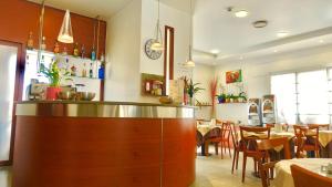 a restaurant with a counter and tables and chairs at Hotel Paris in Mestre