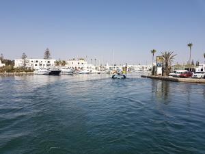 a small boat in the water in a harbor at Appartement Les Rosiers in Hammam Sousse