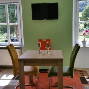 a dining room table with chairs and a television on a wall at ferienhaus-raju-zeltingen in Zeltingen-Rachtig