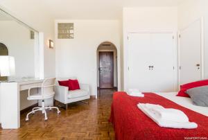 a bedroom with a bed and a desk and a chair at Arcadas Delight in Estoril