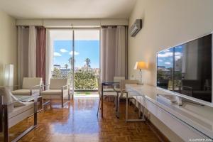 uma sala de estar com uma mesa e cadeiras e uma grande janela em Arcadas Delight em Estoril
