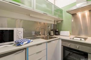 una cocina con fregadero y microondas en Arcadas Delight Studio, en Estoril
