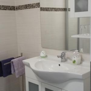 a white bathroom with a sink and a mirror at ferienhaus-raju-zeltingen in Zeltingen-Rachtig +52 photos